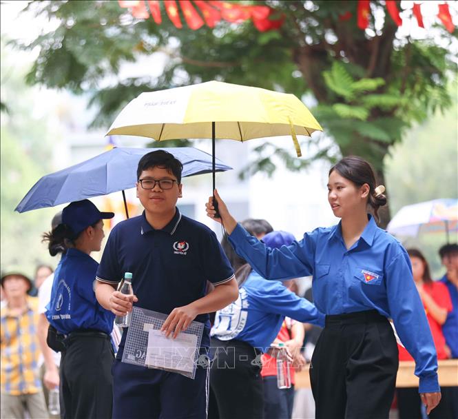 Tình nguyên viên tại điểm thiTrường THPT Trần Nhân Tông nhiệt tình đón các thí sinh tới thi môn Ngoại ngữ. Ảnh: Thanh Tùng - TTXVN